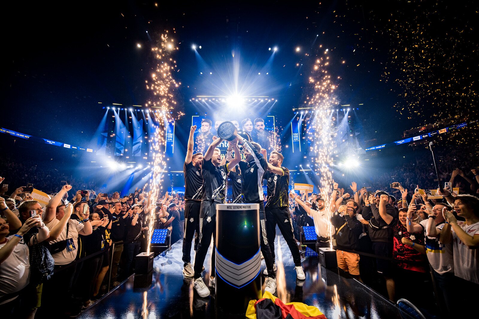 The IEM Cologne 2023 champions lifting the trophy amid sparks and a packed arena crowd.